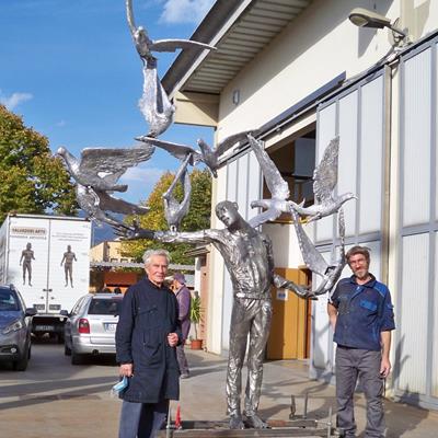 Sculpture composed from a man in stainless steel and the seagulls in aluminium. In this picture the master Giuliano Vangi with a worker